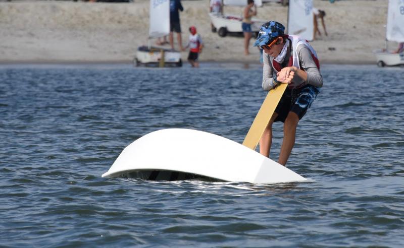 Will DiPaolo of Lewes Yacht Club prepares to lift his Optimist sailboat after taking a dip to cool off before races start July 18.