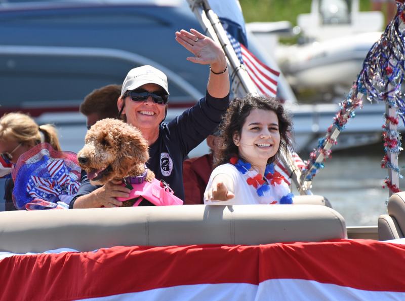 Bev Rosella, left, of Freedom Boat Club waves to the judges with Loredana Rosella and their pup Sirena.