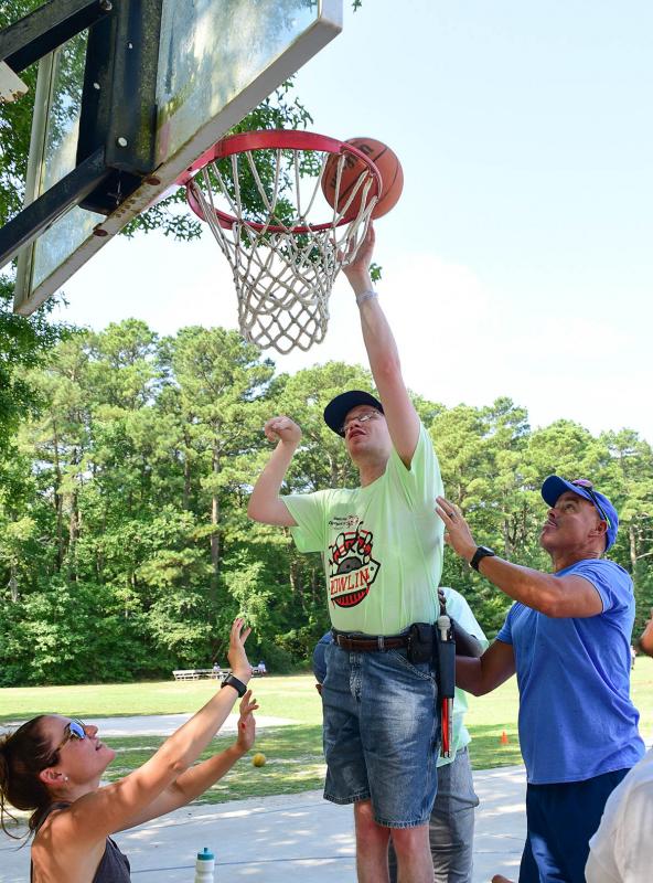 Special Olympics visually impaired athlete Jeff Conk, center, gets an assist from Kylie Frazer, director of youth and school initiatives, and camp counselor Danny Hall.