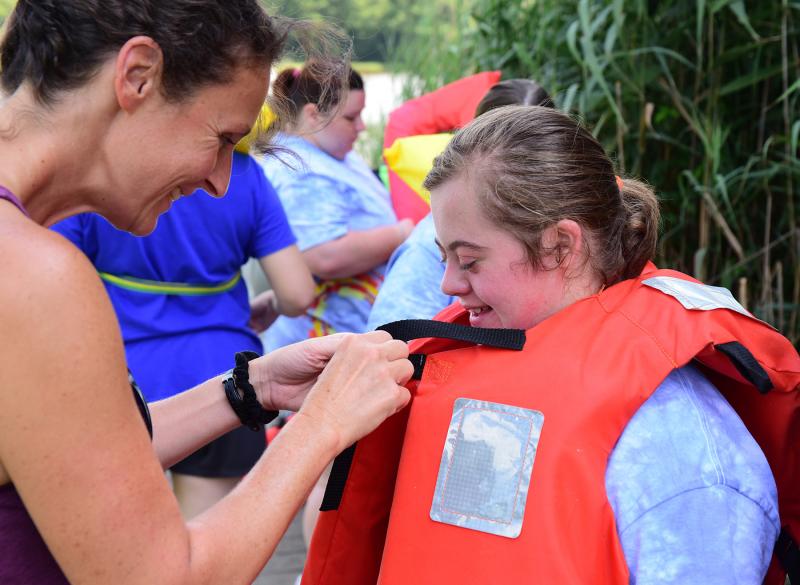 Counselor Lisa Tursi, left, gives a little assistance to athlete Lilly Mullikin before the pontoon boat ride.
