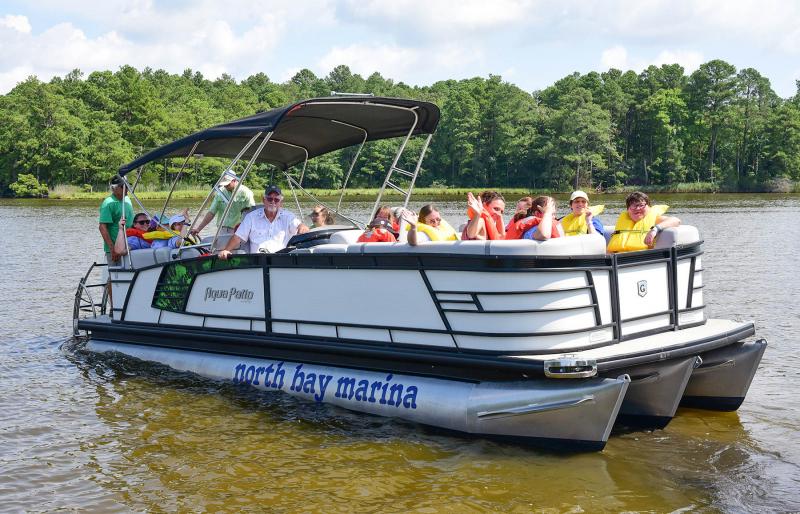 Capt. Paul Daisey takes off for a pontoon ride with the happy athletes on a boat donated by North Bay Marina.