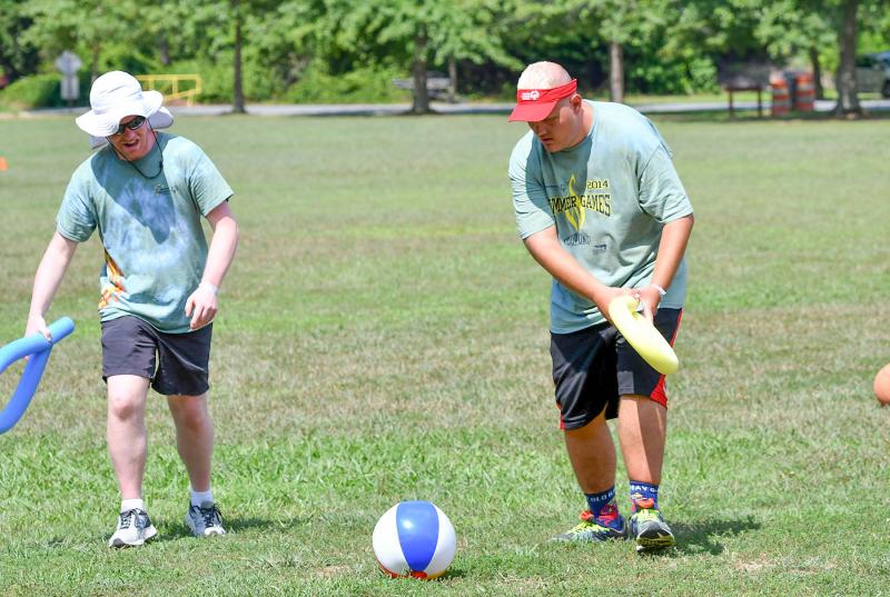Athlete Jeremy Eglit, right, passes the ball to partner Jeff Lovett in the beach ball relay activity.