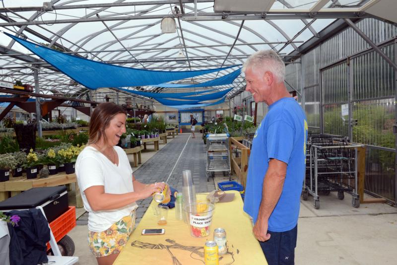 Lyndsey Shockley, left, a sales representative from Crooked Hammock Brewery, laughs with Mark Voelkel, a landscape designer with RSC Landscaping. Brews, BBQ and Bushes
