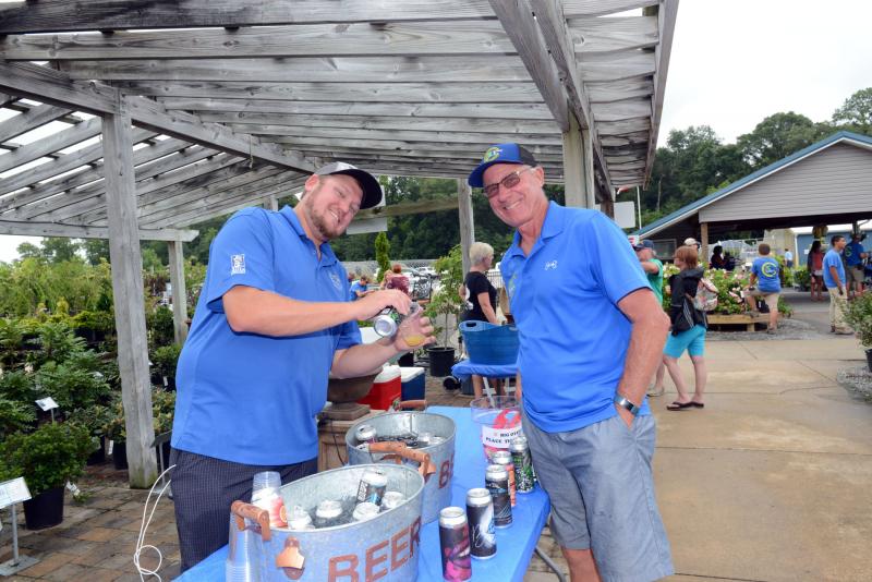 Mike Anderson, left, director of sales for Big Oyster Brewery, pours a brew for ECGC owner Rick Cordrey. Brews, BBQ and Bushes