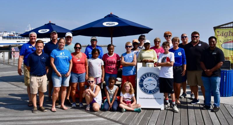 Big Brothers, Big Sisters of Delaware children, families and Freedom Boat Club staff join for a group photograph near the gangway to the floating dock at the Cape May-Lewes Ferry terminal.