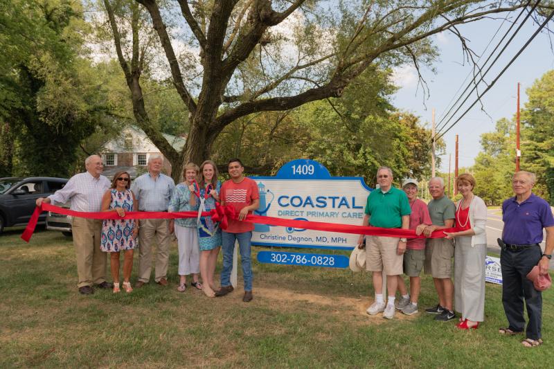 Joining Dr. Chris Degnon at the ribbon cutting are her parents, City of Lewes Mayor and Council members, and Lewes Chamber representatives. Shown are (l-r) George Degnon, Lewes Chamber Vice President Nikky Fisher, Mayor Ted Becker, Marge Degnon, Dr. Chris Degnon, Coastal DPC Office Administrator Matt Bueno, Deputy Mayor Fred Beaufait, Councilwoman Bonnie Osler, Councilman Dennis Reardon, chamber Executive Director Betsy Reamer and Councilman Rob Morgan. SUBMITTED PHOTO