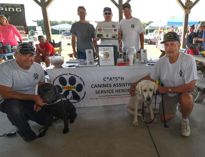 Working the CASH (Canines Assisting Service Heroes) organization are (l-r) Bryan Clark, Major Nelson Miller, Winston Burns, Joe Startt, and Dave Curnock and Gunny.