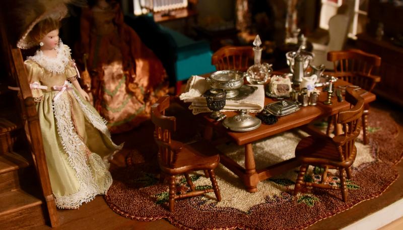 An elegant wooden table is set for dinner in the dining room of this colonial house. The house was purchased at a local antique shop and renovated with a new roof, stucco, paint and brick work.