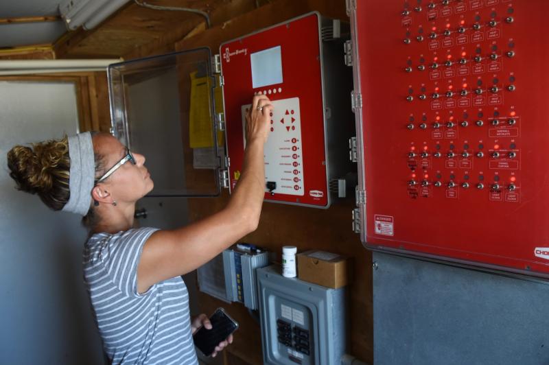 Lise Masten checks the large control box as she begins her early-morning rounds. RON MACARTHUR PHOTOS