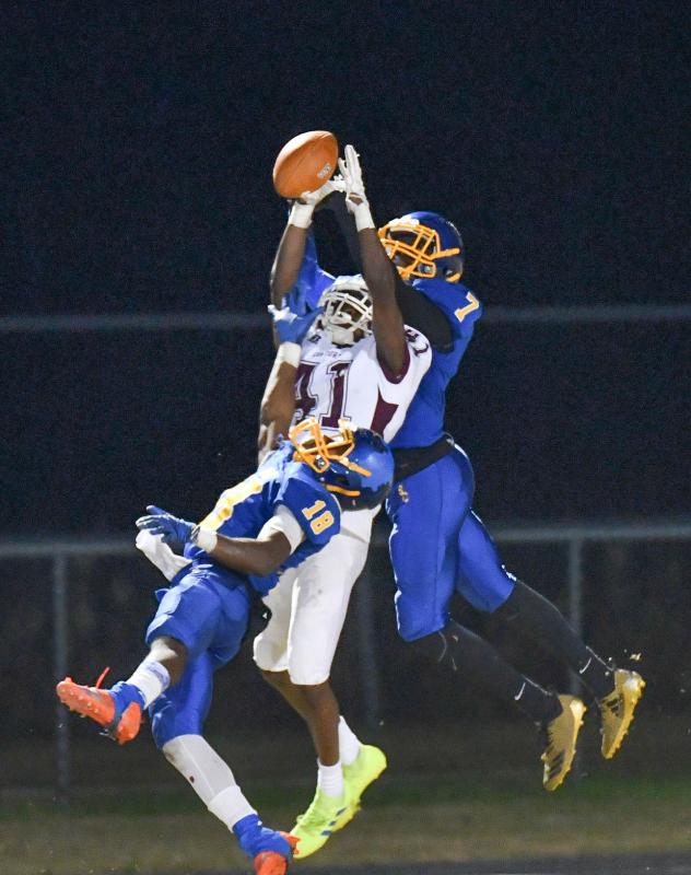 Concord’s Zion Larkins battles for a catch with Central’s Phillip Stratton, bottom, and Domonique Smith.