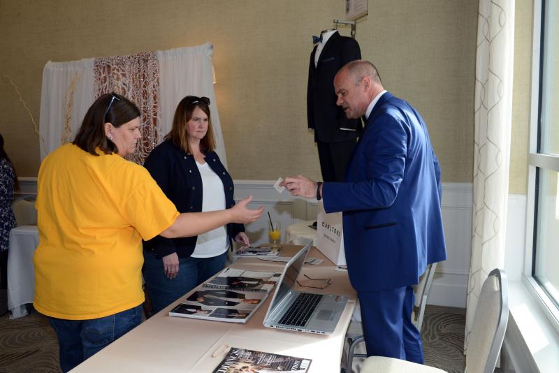 Trey Kraus, owner of Carltons in Rehoboth Beach, talks with Stacy Knudsen, left, and Deanna Kilber about formal wear. Wedding give away