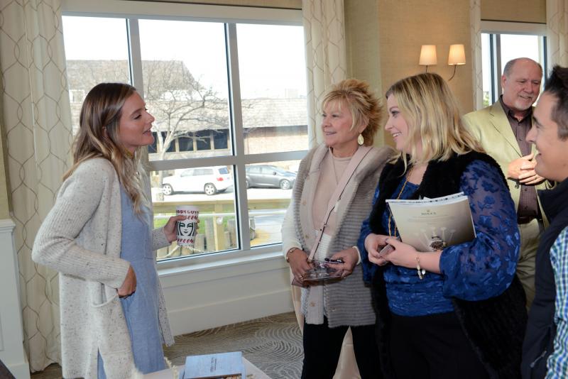 Leah Adkins Natural Light Photography owner Leah Adkins, left, talks with Andrea McGovern, center, and Morgan McGovern about photo packages. Wedding give away