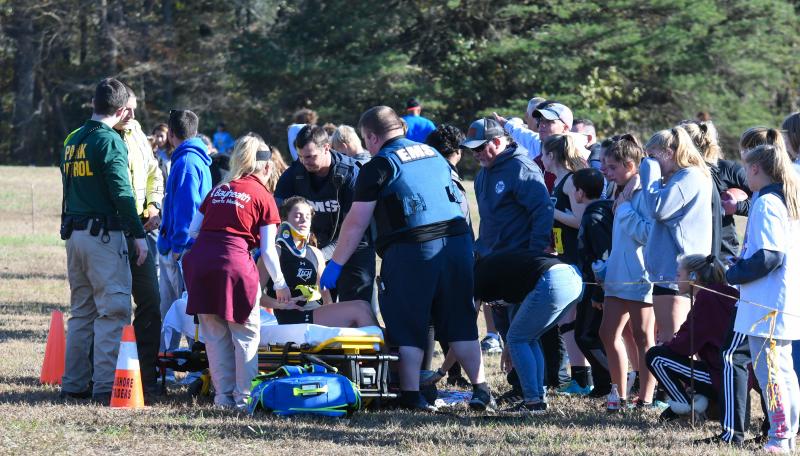 Olivia Hudson is rolled from the race course moments before a herd of harriers rumbled to the finish line in the varsity boys’ race.