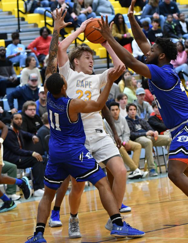 Cape senior Samuel Luciano-Solomon, center, gets out of a tough situation between Dover’s Wanya Wise, left, and Shamir Nelson.