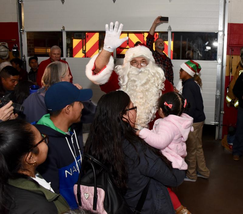 Santa Claus is swarmed as he makes an entrance at the end of the event.