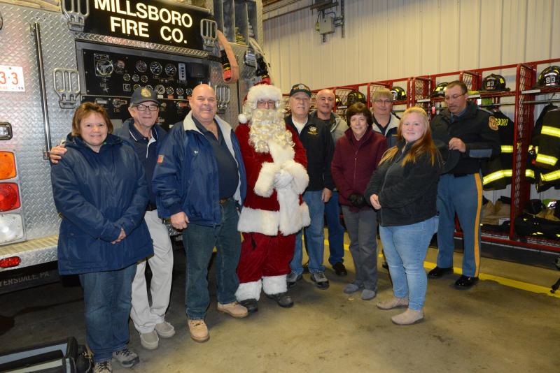 The gift-giving partners gather at the Millsboro Fire Hall prior to the presentation. Shown are (l-r) Joan and Bob Waegele, FOP President Bob Schappert, Lewes Fire Department’s Brian “Santa” Morley, Al Weir, Frank Cultrera, Connie Cultrera, Sherman Littleton, Lewes Fire Department’s Katelyn Robinson, and Troop 4’s Cpl. Mike Trestka. FOP gift giving