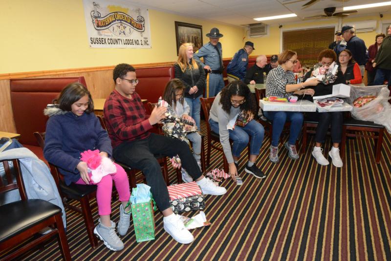 The Arbrona family dined at the Country Kitchen in Millsboro, and Santa and his helpers came in and brought the family to the back room where there were dozens of gifts along a wall. Shown unwrapping gifts are (l-r) Janelys, Jatniel, Jamie, Jaydy, mother Maria and aunt Laudys Abrona. FOP gift giving