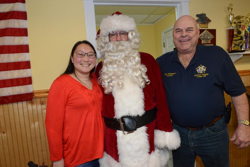 Liz Scheor, left, a counselor with Delaware Hospice Camp New Hope, had spoken with Jatniel Arbrona and learned of the family’s difficulty. Scheor contacted FOP and the gifts started pouring in. Shown are (l-r) Scheor, Brian “Santa” Morley, and FOP Lodge 2 President Bob Schappert. FOP gift giving