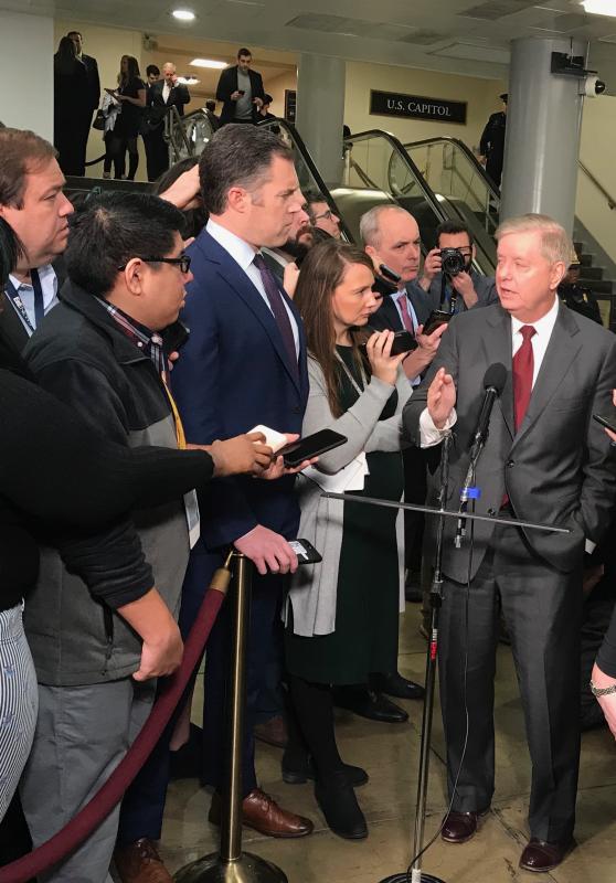 Broadcast, internet and print news people know where they can catch up with senators on their way between offices and the capitol building. Here, South Carolina Republican Sen. Lindsay Graham takes questions before the day’s proceedings.
The next photo shows Sen. Coons doing the same, providing the reporters with an opportunity for balanced coverage.