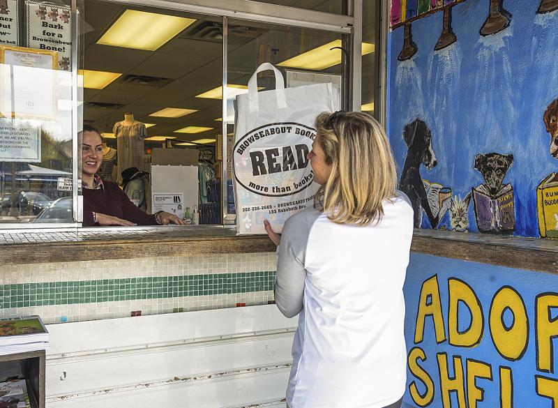 Susan Gaughan gets a bag of items from Alex Jones at Browseabout Books. “I could have shopped at Amazon but I decided to support our local shop,” said Gaughan. DENY HOWETH PHOTO