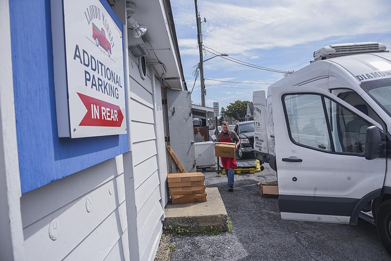 Darren Purcell carries more supplies of meat to Lloyd’s Market in Lewes. It’s bigger than July numbers, he said. DENY HOWETH PHOTO