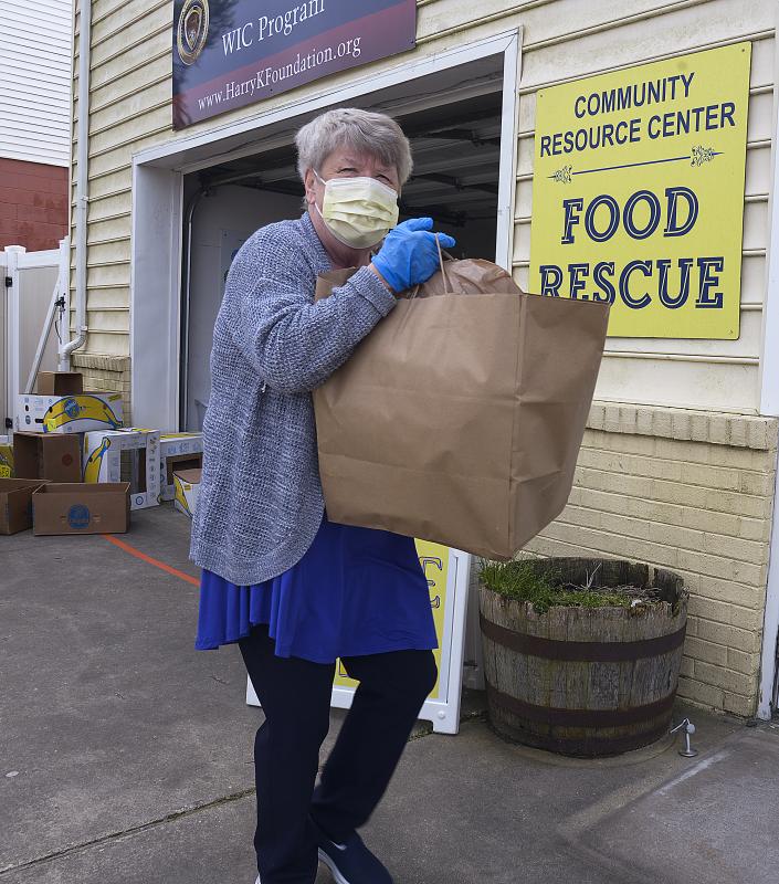 Beth Conrad helps carry a bag to a car at the Cape Henlopen Food Basket on Oyster House Road in Rehoboth.