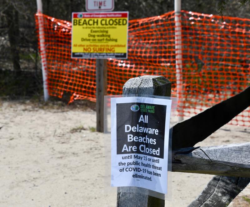 Nearly all beach-access points in Cape Henlopen State Park are closed, although the sign in the background notes that people are permitted to exercise or walk a dog or drive on to surf fish with some restrictions.