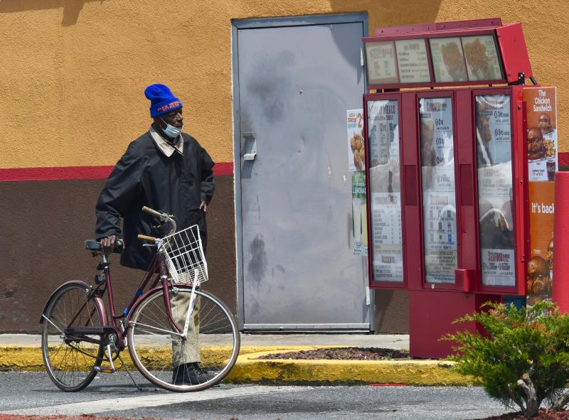 Not everyone drives in a drive-through, as this cyclist at Popeyes near Rehoboth Beach proves. Since most fast-food restaurants have closed their interiors, people resort to any means they can to get lunch. Lines at fast-food restaurants have been long. RON MACARTHUR PHOTO