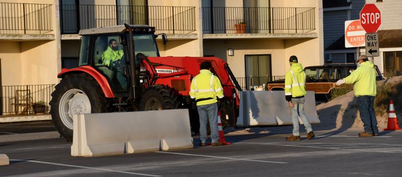 At first light May 14, City of Lewes workers reposition barricades in the Savannah Road parking lot.