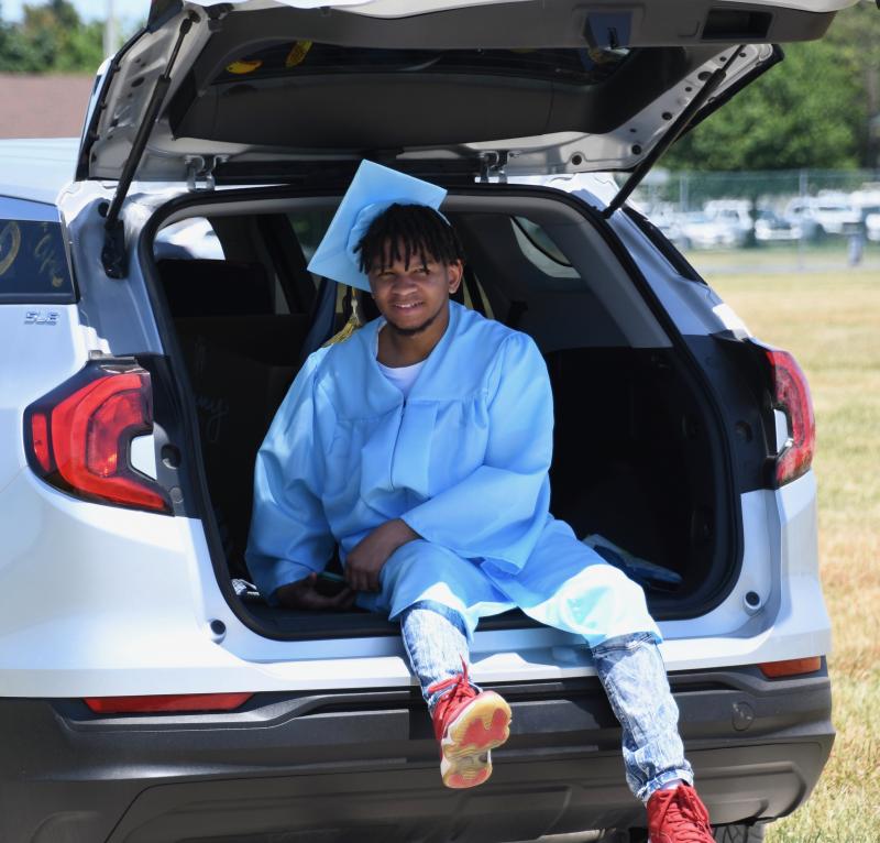 Decked out in his cap and gown, Class of 2020 member Daniel Wright takes a ride during the drive-thru.