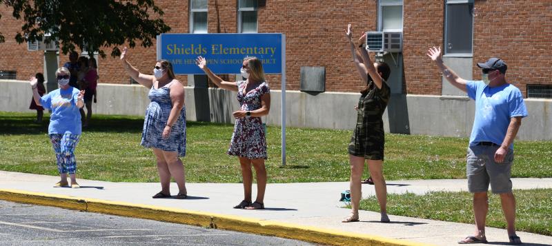 Shields Elementary staff wave to their students as they drive by the front of the Lewes school. They are (l-r) Robin Wray, Tara Davis, Meghan Catts, Malorie Tartal and John Sell. RON MACARTHUR PHOTO