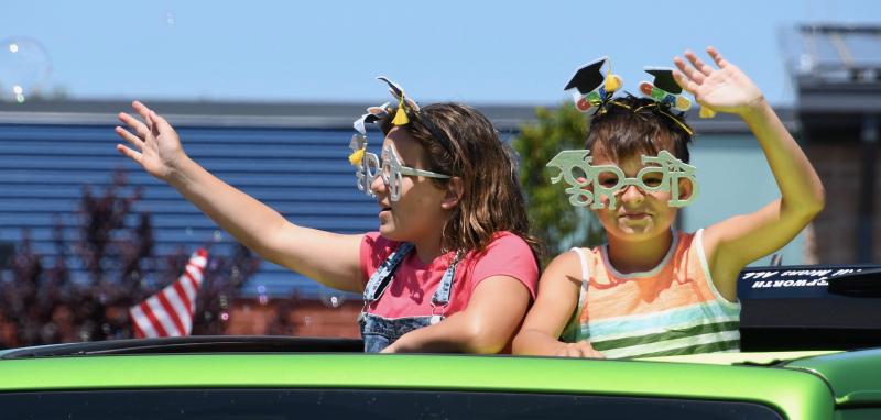 Sporting fancy glasses, Love Creek Elementary fifth-graders Jiayanna and Kayden Holt wave to their teachers. RON MACARTHUR PHOTO