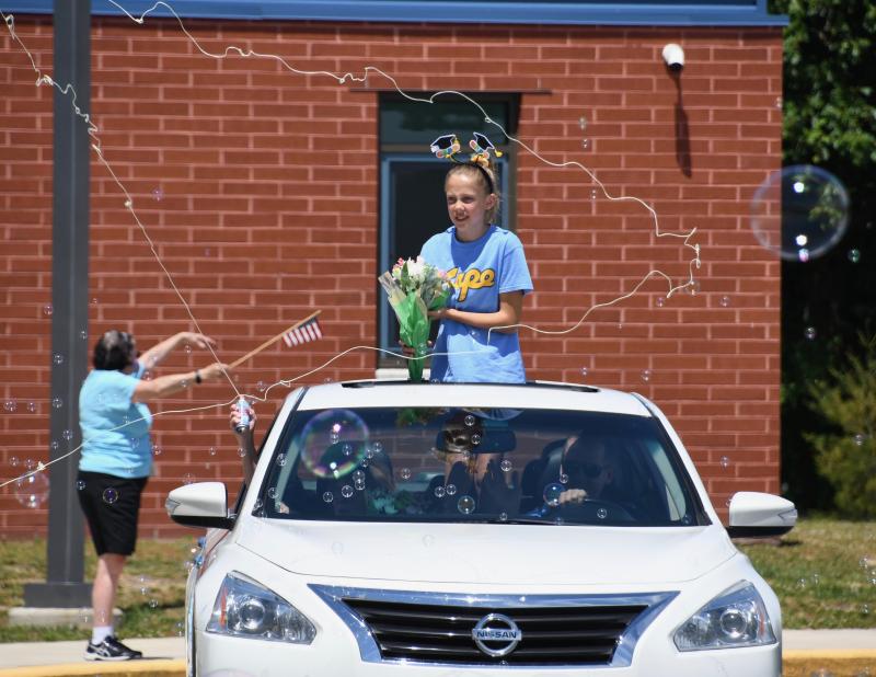Amid a sea of Silly String, Love Creek Elementary fifth-grader Emma Thompson prepares to throw flowers to her teachers. RON MACARTHUR PHOTO