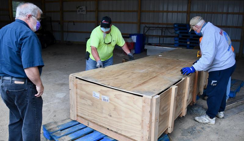 Arizona Task Force Chairman Cliff Geisler, left, and Fort Miles Historical Association President Gary Wray assist Billy Mitchell of Corrado Construction.
