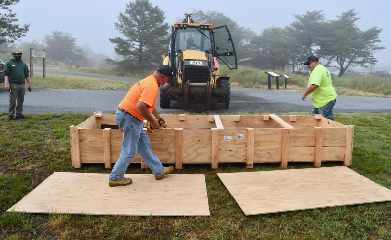Corrado Construction’s Keven Rains, left, and Billy Mitchell prepare to remove the Arizona steel relic from the shipping crate after it was moved to Fort Miles.