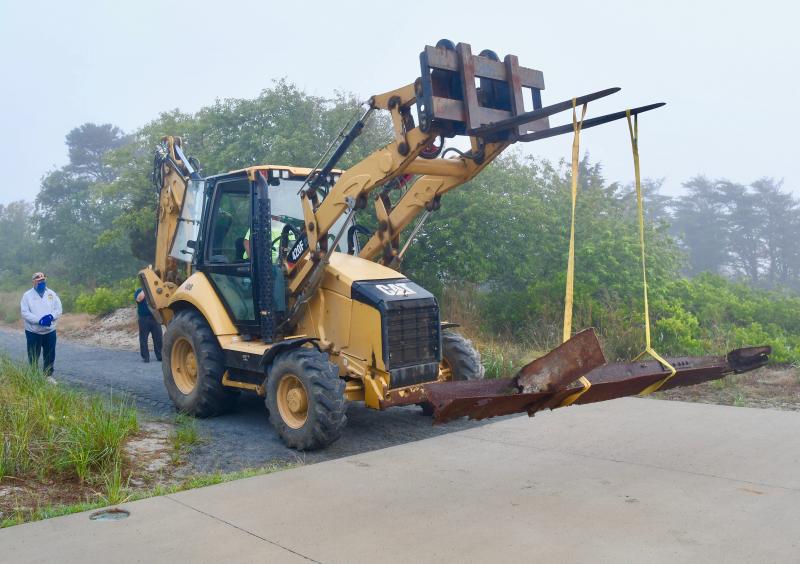 The USS Arizona artifact is moved to the edge of the concrete pad in the area where it will eventually be on display.