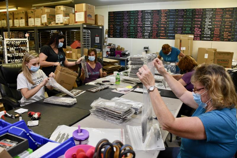 In the production room are (l-r) Tori Givens, Amber St. Clair, Amy Wittman, Deb Evans, Cindy Corona and Sue Hennessey. They are wrapping and packing signs for deliveries across the country.