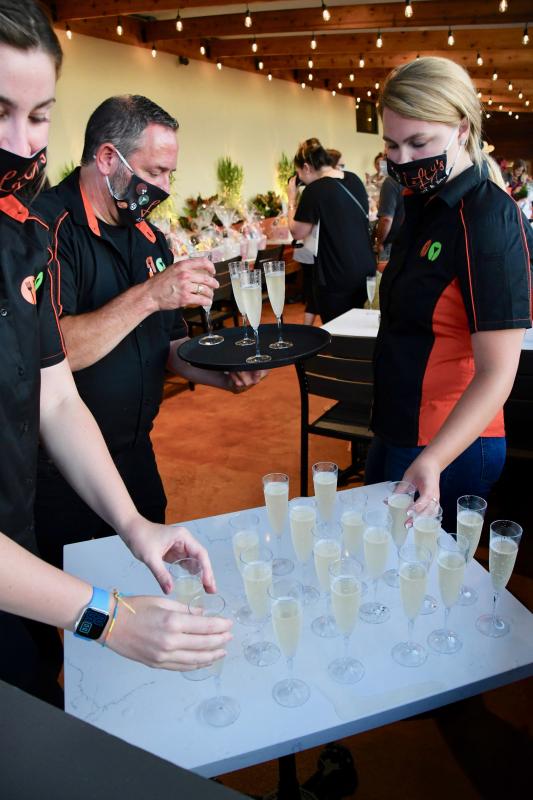 Employees (l-r) Maddie Franke, Gus Gerontakos and Maddy Bandy prepare to serve champagne on the new Lefty’s patio.
