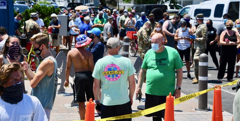 A long line of people waits along Saulsbury Street in Dewey Beach for their turn to take a COVID-19 test.