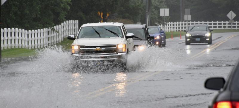 Cars and trucks drive through water on flooded Plantation Road between Lewes and Rehoboth Beach. Any significant rainfall usually floods the roadway. RON MACARTHUR PHOTO