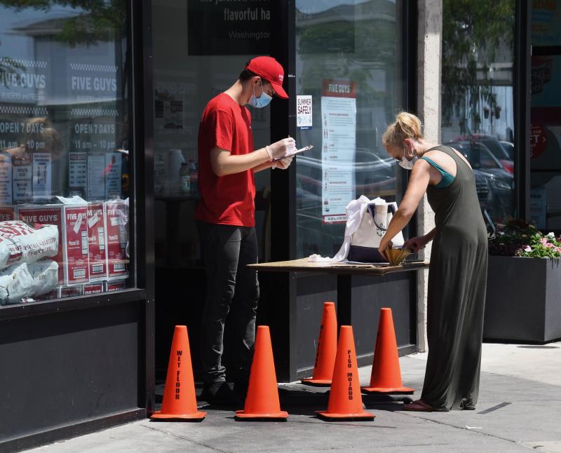 Some restaurants have not opened their doors. Five Guys on Rehoboth Avenue takes orders at the front door.
