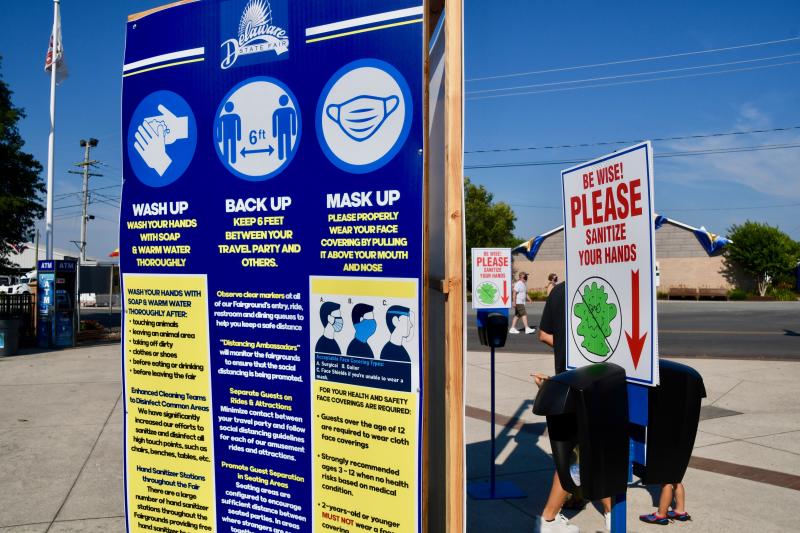 A sign listing restrictions under the approved plan to open the Delaware State Fair is posted near the entrance, as is one of the many sanitizing stations throughout the fairgrounds. The fair continues through Saturday, Aug. 1. RON MACARTHUR PHOTOS