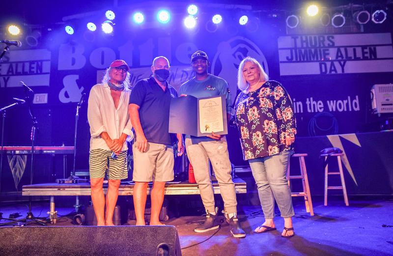 Jimmie Allen receives a Jimmie Allen Day House of Representatives Tribute from Speaker of the House Pete Schwartzkopf before his Aug. 13 concert at the Bottle & Cork in Dewey Beach. Shown are (l-r) Highway One owner/managing partner Alex Pires, Schwartzkopf, Allen and Highway One talent buyer/promoter Vikki Walls. DAN COOK PHOTOS
