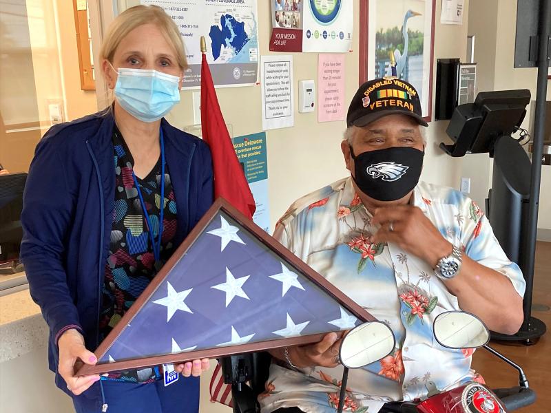 Mary Lou Kline, a registered nurse with Veterans Affairs, receives a flag from Chaplain Al “Mr. Positive” Kraft at the Sussex County Community Based Outpatient Clinic in Georgetown. SUBMITTED PHOTO