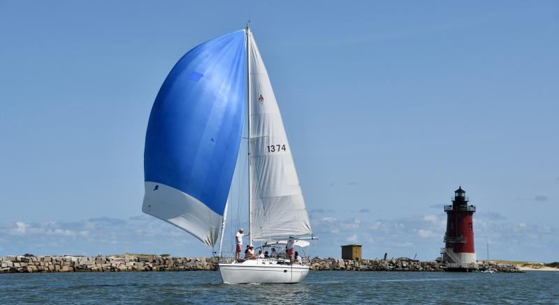 Skippered by Nick Carter, Delgato has its spinnaker flying as it leaves the breakwater and East End Lighthouse. Delgato finished fourth in the annual Labor Day race.