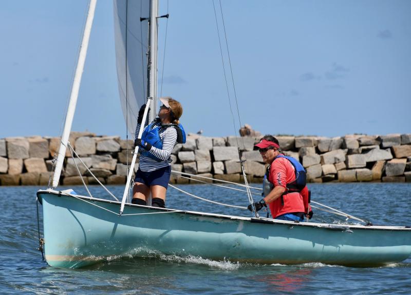 Paynter and Patty Ingram prepare to raise the spinnaker on their way to a second-place finish in the Mobjack class.