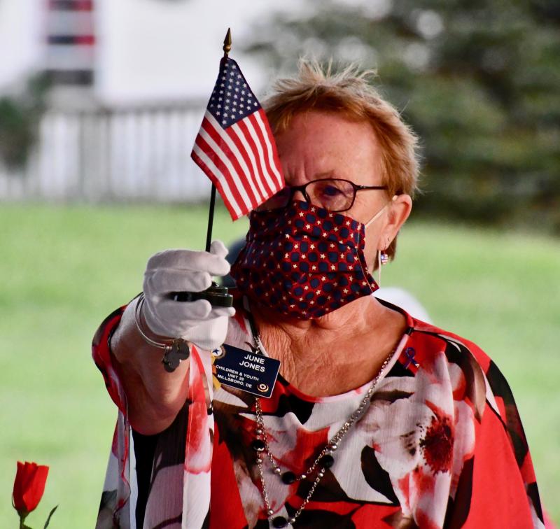 June Jones, Post 28 Auxiliary vice president, holds up a U.S. flag in honor of those missing in action.