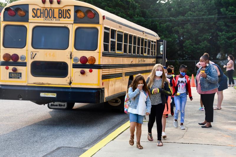 One of nine buses arrives to drop off students at the side door of Shields Elementary School on the first day of school.