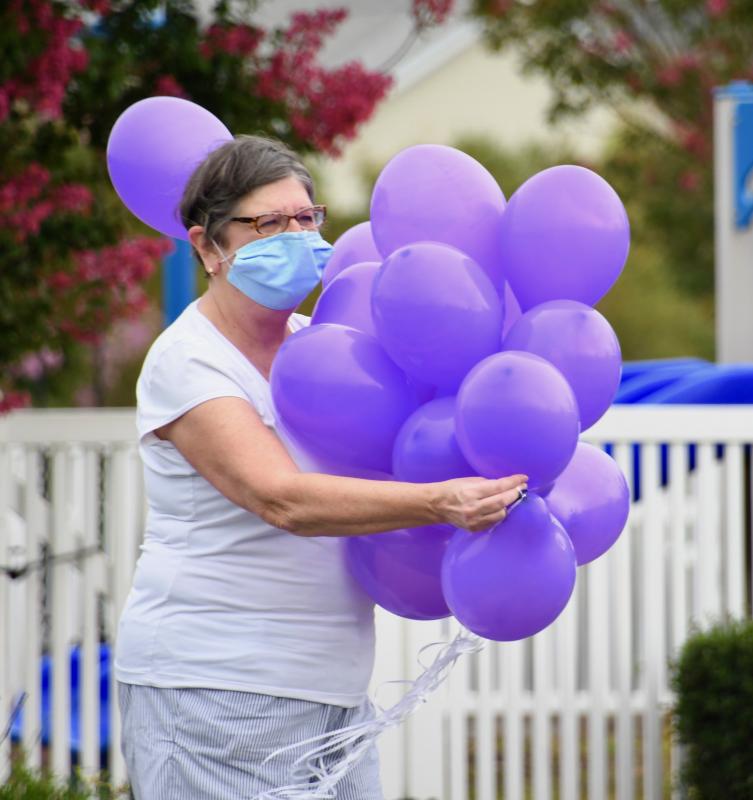 Event coordinator Hilda Adams has an armful of purple balloons to hand out to participants taking part in a Sept. 26 Walk to End Alzheimer’s at the Villages of Five Points.