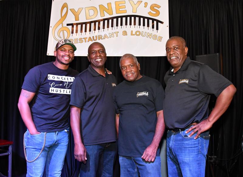 Jimmie Allen, left, poses with Sydney’s partners/owners Elton Lewis, Ed Waples and Anthony Lewis. Not shown are Belinda Waples and Patricia Lewis.